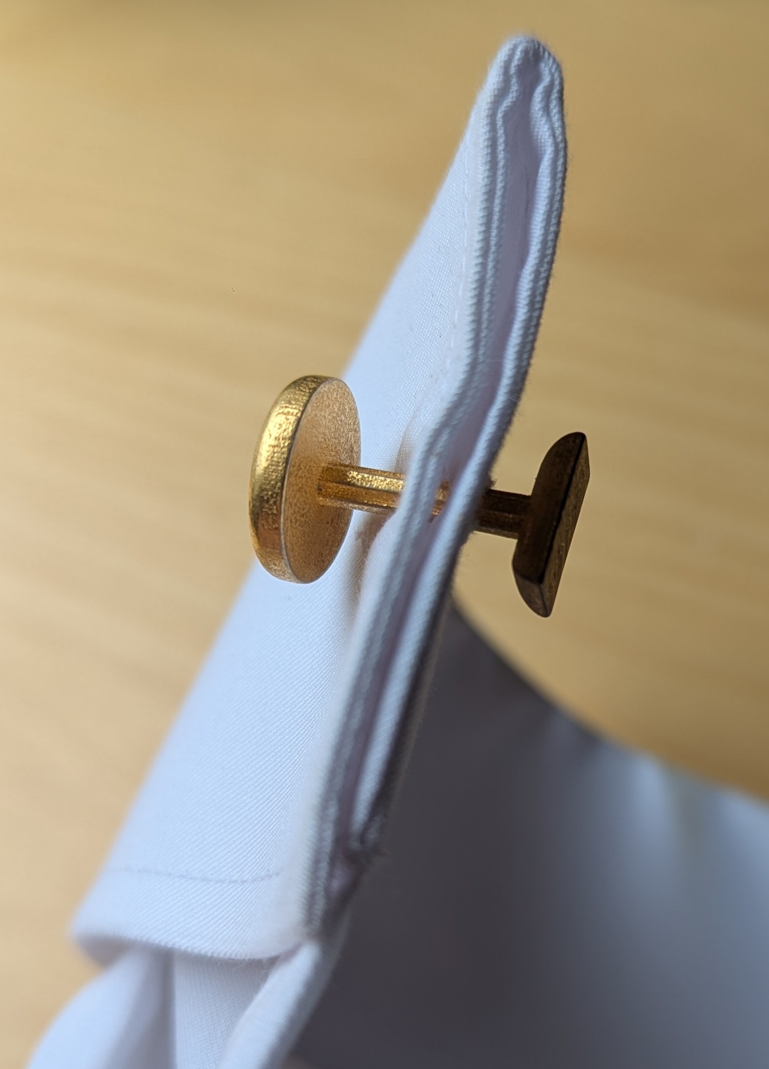 Side view of gold cufflink showing mechanism detail