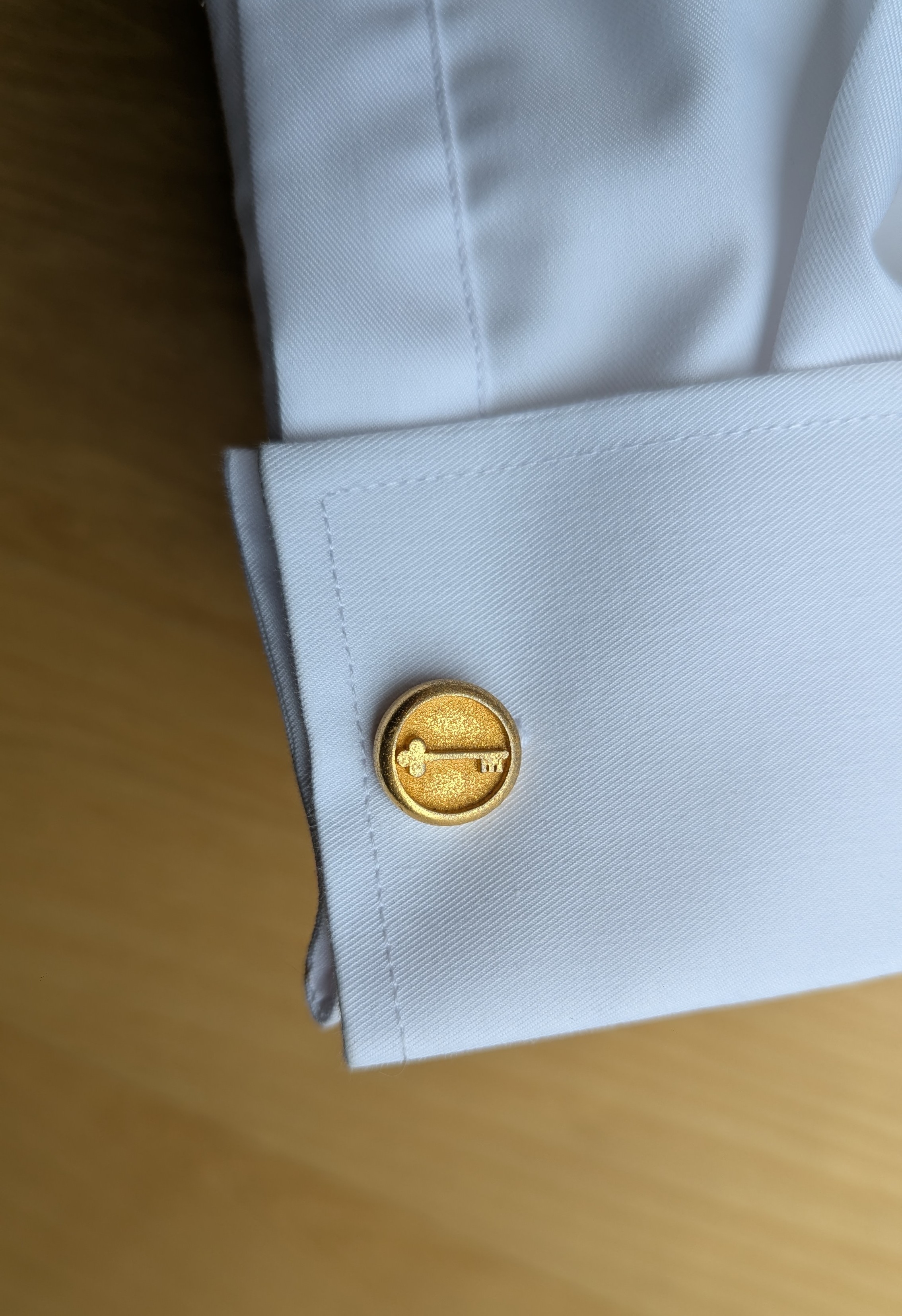 Gold 3D printed cufflink with key design on white dress shirt